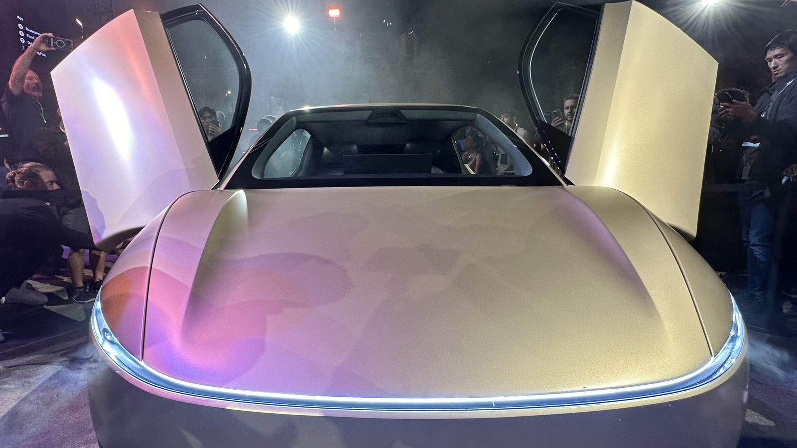 A Tesla Cybercab, front view, with both doors raised